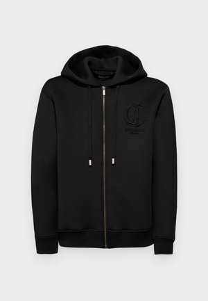 Felpa nera con zip realizzata in tessuto morbido, dotata di un grande cappuccio, tasche frontali, cordini regolabili e un logo in rilievo sul petto.