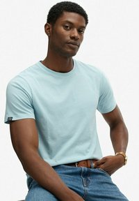 Lichtblauw T-shirt met korte mouwen van katoen, met een klassieke ronde halslijn en een klein label aan de linkermouw.