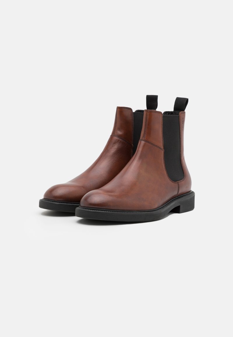 Bruna läder Chelsea-boots med elastiska sidopaneler, rund tå och svart gummisula. Har dragflikar för enkel påtagning.