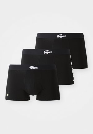 Lot de trois boxers noirs avec ceintures élastiques. Présente un logo crocodile brodé blanc et le texte "LACOSTE" sur une des paires.