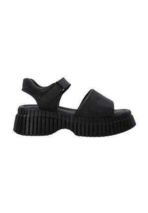 Černé platformové sandály s robustní ribbed podrážkou, otevřenou špičkou, širokým předním páskem a nastavitelným páskem kolem kotníku.