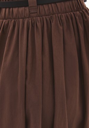 Brown pleated skirt with an elastic waistband and a black belt threaded through belt loops.