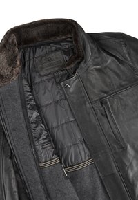 Czarna skórzana kurtka z pikowanym wewnętrznym podszyciem, kieszenią na piersi zapinaną na zamek oraz brązowym kołnierzem z sztucznego futra, oznaczona "Milestone Leather Collection."