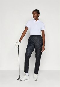 Balta polos krekls ar īsām piedurknēm un apkakli, kombinēts ar melnām ķemmētām biksēm. Persona tur golfa klubu, valkā baltus apavus un cimdu.