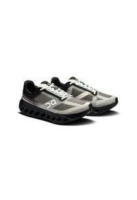 Szare i czarne buty do biegania z siateczkową cholewką, zaokrąglonym czubkiem, teksturowanymi detalami oraz wyściełaną podeszwą z dużymi wycięciami.