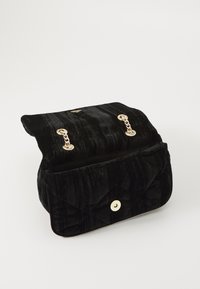 Borsa in velluto nero con design trapuntato, hardware in tonalità oro, chiusura a patta e bottone magnetico rotondo. Interno foderato.