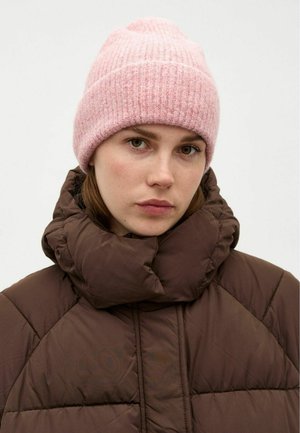 Rosa strikket hue med ribbet tekstur, parret med en brun puffjakke med højt krave og quiltede sektioner, hvilket skaber et lagdelt look.