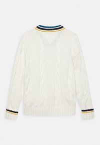 Biały sweter z kaszmirowym splotem, z prążkowanym wykończeniem u dołu i na mankietach, z żółtymi, czarnymi i niebieskimi paseczkami na kołnierzu oraz końcach rękawów.