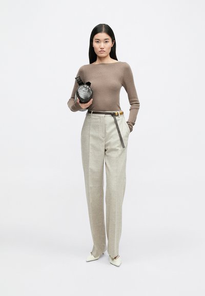 Brūns ribots garām piedurknēm tops, augsta vidukļa gaiši bežīgas bikses, melna apaļa soma, neitrāla fonā, minimālisma dizains.