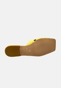 Infradito giallo con superficie liscia, design aperto e suola piatta. Presenta marchi impressi e una parte inferiore texturizzata per una maggiore aderenza.