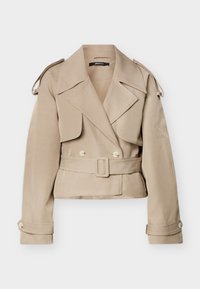 Μπεζ κοντό παλτό τρανς με φαρδιές πέτρες, διπλή σειρά κουμπιών, ζώνη στη μέση, επιθέματα στους ώμους και κουμπωτά μανίκια.