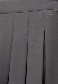 Ciemnoszara plisowana tkanina o subtelnej fakturze z małym wyszywanym podwójnym logo "R" w pobliżu górnej krawędzi.