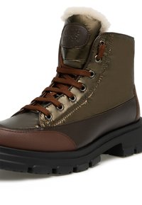 Hnědé a kovově zelené kotníkové boty na šněrování s chlupatou podšívkou, mají robustní gumovou podrážku a texturované kožené detaily.