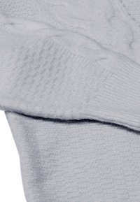 Jasnoszary sweter z miękkiego materiału, z prążkowaną teksturą i gładkimi sekcjami, z różnorodnymi widocznymi wzorami dziania.