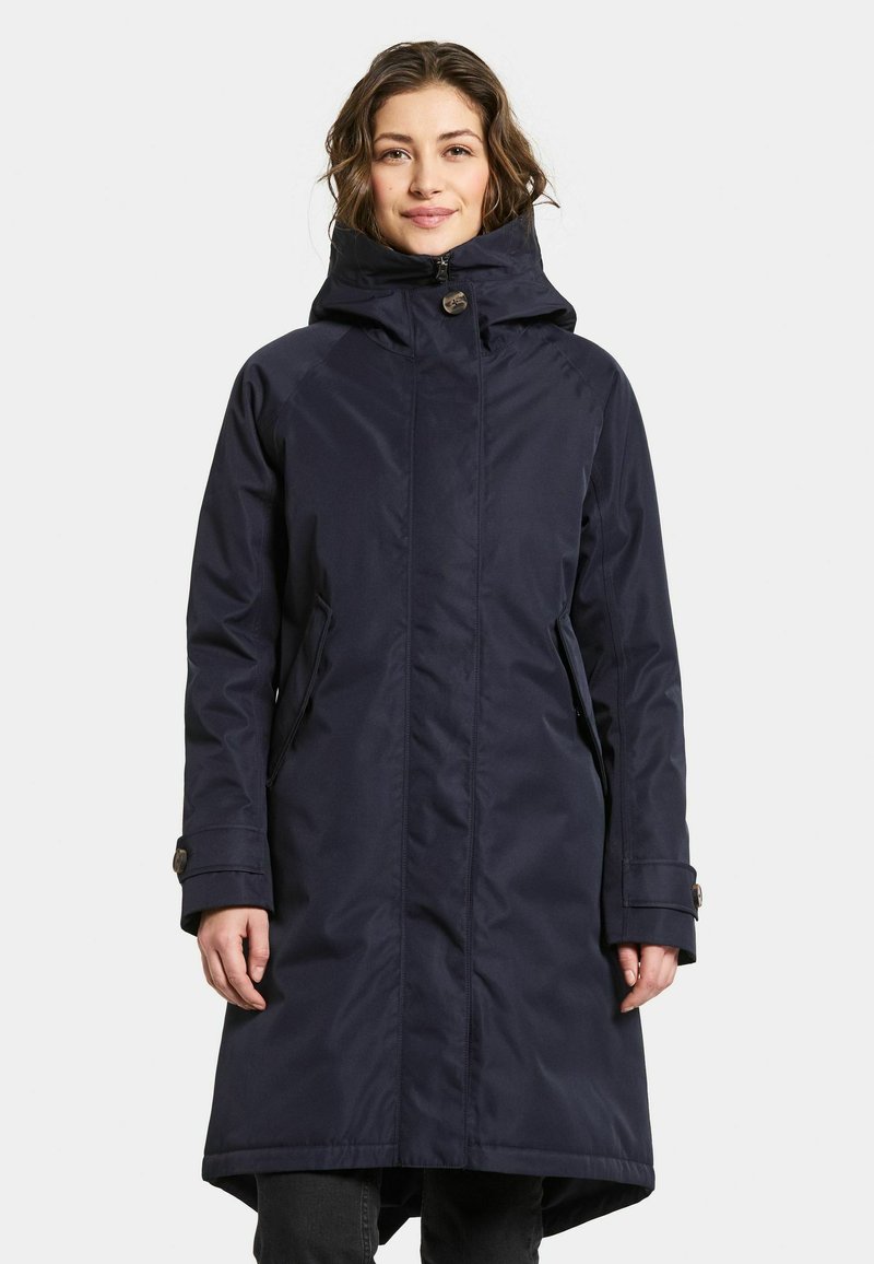 Marinblå vattentålig jacka med hög krage, dragkedjestängning och sidofickor. Har knappdetaljer på ärmarna för en säker passform.