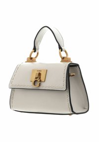 Biała skórzana torebka z czarnymi krawędziami, złotym okuciem i charakterystyczną klamrą z logo. Posiada zaokrąglone uchwyty i detale w postaci przeszyć.
