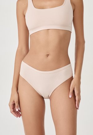 Nude nahtloser Bralette und passende hoch geschnittene Panty. Weicher Stoff, dehnbare Passform, minimale Nähte und ein simples, modernes Design.
