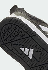 Crni đon sportske tenisice s teksturiranim gumenim hvatom, bijelim detaljima i geometrijskim uzorkom. Na bočnoj strani vidljiv je tekst "Non marking".