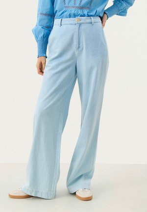 Light blue wide-leg pants made of denim with a high waist, featuring a front button closure and subtle texture, styled with white sneakers.