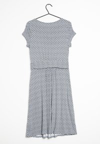 Mönstrad klänning i blått och vitt, med korta ärmar, en insvängd midja och en svängig kjoldesign. Tyget  är mjukt med en texturerad finish.