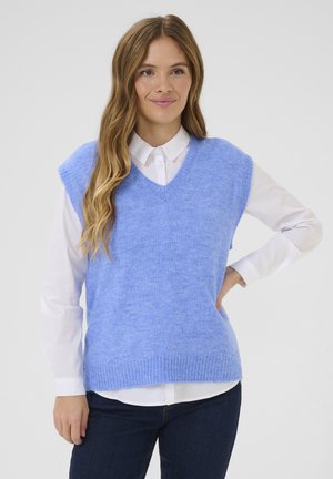 Un pull sans manches bleu clair en tissu doux et texturé avec un col en V, porté sur une chemise blanche à boutons. Ourlet côtelé en bas.