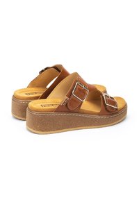 Sandalias de plataforma de cuero marrón con dos correas anchas, detalles de hebilla plateada y una base con textura de corcho que incluye una plantilla acolchada.