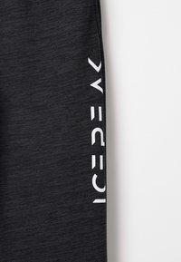 Schwarze Sporthosen mit strukturiertem Finish. Mit einem auffälligen weißen Logo auf der linken Seite. Elastischer Bund für zusätzlichen Komfort.