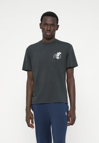 Tamsiai pilkas medvilninis marškinėliai su maža balta erelio grafika ir žvaigždėmis kairėje krūtinės pusėje. Trumpomis rankovėmis ir apvaliu iškirpimu.