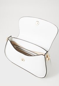 Borsa bianca con esterno testurizzato, accessori in oro e chiusura a pattina. L'interno presenta diversi scomparti e una fodera liscia.