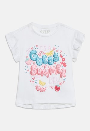 Λευκό πουκάμισο με κοντά μανίκια και βολάν, με πολύχρωμο γκλίτερ κείμενο "Guess Summer" και καλοκαιρινά εικονίδια όπως φράουλες και φέτες λεμονιού.