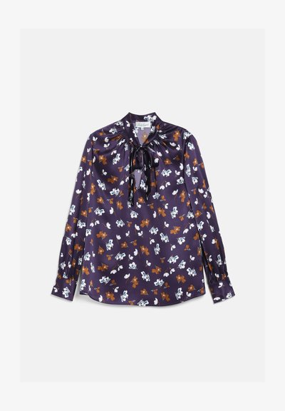 Blouse violette à manches longues avec motif floral marron et blanc, encolure froncée, et détail nœud à l'avant.