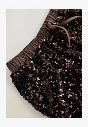 Black sequined shorts featuring a gathered waistband and a satin ribbon tie detail, showcasing shiny rose-gold sequins for added texture.