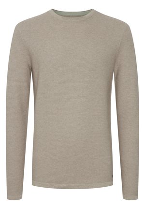 Beżowa koszula z długim rękawem, wyróżniająca się fakturowanym wzorem dzianiny, okrągłym dekoltem oraz kontrastującą wewnętrzną kołnierzykiem z subtelnymi akcentami.