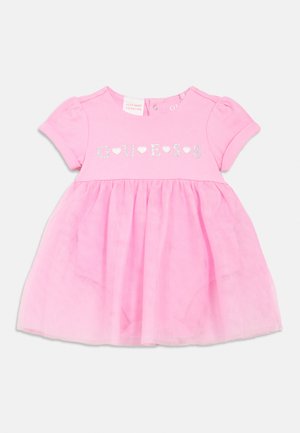 Pink baby dress with a cotton top and a tulle skirt. Front features silver "GUESS" text with hearts. Short puff sleeves, button closure at neck.