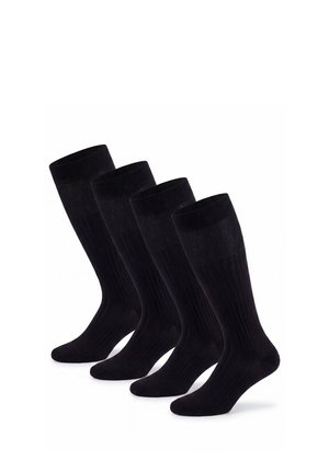 Vier Paar schwarze knielange gerippte Socken nebeneinander auf weißem Hintergrund angeordnet.