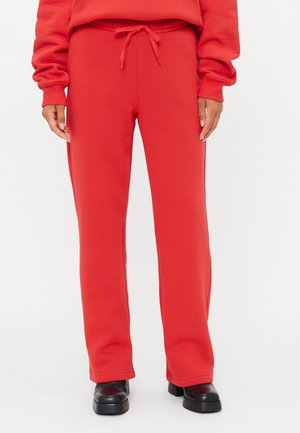 Rode sweatpants van zacht materiaal met een elastische tailleband en een trekkoord, met een recht gesneden ontwerp en zonder zichtbare patronen.