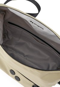 Beige Stofftasche mit glatter Textur, ausgestattet mit einem grauen Innenfutter, einer Reißverschlusstasche und zwei Druckknopfverschlüssen auf der Vorderseite.