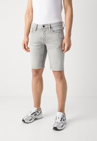 Light gray denim shorts with a slim fit, featuring a buttoned front, belt loops, and frayed hems. Paired with white and gray athletic shoes.