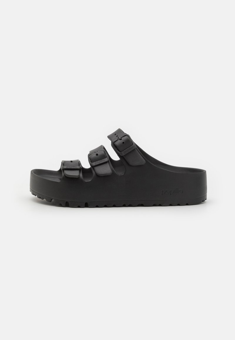 Zwarte rubberen slipper met drie verstelbare riemen met gespen, een dikke zool en een gestructureerde loopvlak voor grip.