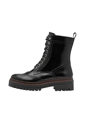 Svarta läderankelboots med brogue-detaljer, snörning framtill och en tjock gummisula. Har en robust klack och draganordning.
