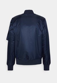 Námořnická modrá bomber bunda s elastickými manžetami, pasem a límcem, zobrazená zepředu na jednoduchém bílém pozadí.