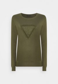 Maglione verde oliva con maniche lunghe, scollo rotondo e una toppa triangolare con borchie sul davanti. Texture liscia.
