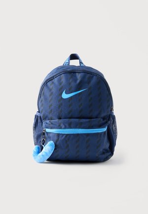 Plavi Nike ruksak s crnim dijagonalnim prugama, svijetloplavim logom i patentnim zatvaračem, mrežastim bočnim džepovima i mekanim plavim privjeskom pričvršćenim na prednji džep.