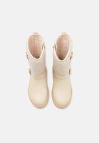 Beige ankle boots with a textured wool upper, smooth leather lower, and two decorative gold-tone buttons on the side. Rounded toe design.