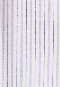 Tissu blanc avec des rayures verticales bleues et bleu clair, présentant un motif tissé texturé.