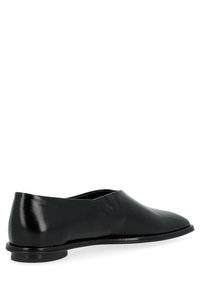 Mocassins en cuir noir au design épuré et à l'avant rond. Présentent une finition lisse, des coutures minimales et une semelle discrète.