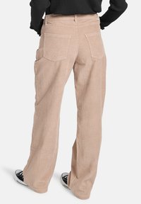Beige corduroy broek met wijde pijpen, voorzien van twee achterzakken en zijzakken, met verticale ribbeltextuur en een losse pasvorm.