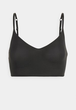 Black, seamless bralette with a V-neck design, adjustable straps, and a smooth, knitted texture. No underwire or padding.