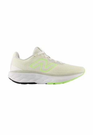 Zapatilla de running beige claro con detalles en verde neón, entresuela blanca, suela exterior negra y verde, y parte superior de malla con cierre de cordones.