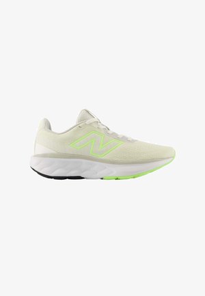 Zapatilla de running beige claro con detalles en verde neón, entresuela blanca, suela exterior negra y verde, y parte superior de malla con cierre de cordones.